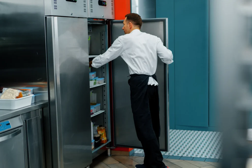 professional-kitchen-chef-looks-into-the-fridge-an-2024-12-05-13-22-25-utc